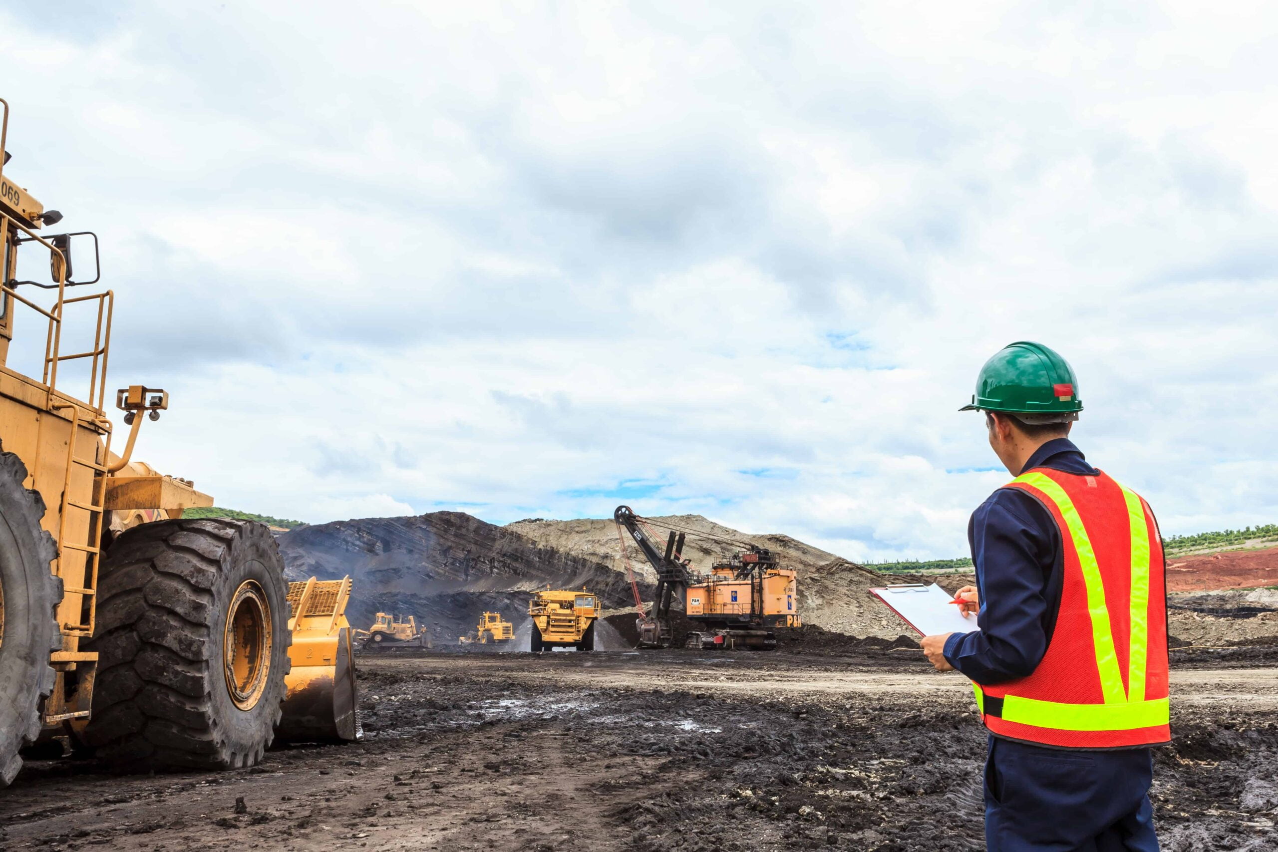 A worker is standing in front of a bulldozer, vulnerable to slip and fall accidents.