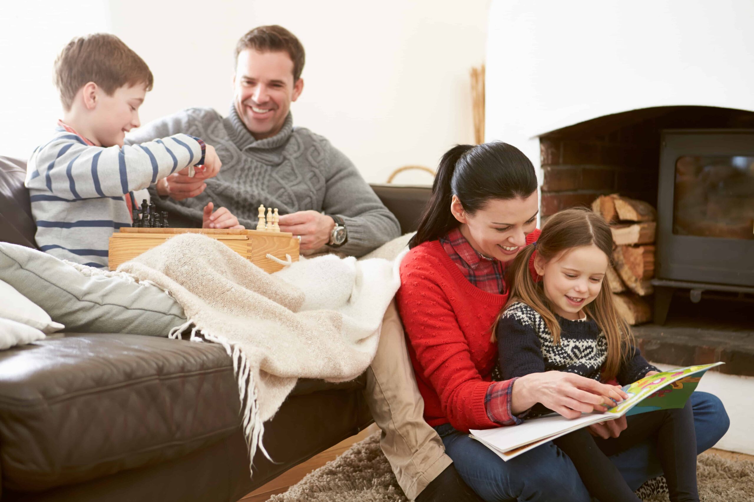 A family enjoying a book by the fireplace.