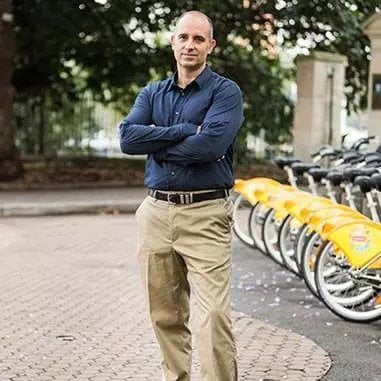 A man standing in front of a row of bicycles in Brisbane.