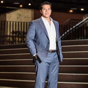 A man in a blue suit standing on stairs in Brisbane.