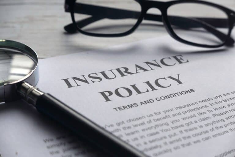 Insurance policy with glasses and magnifying glass.