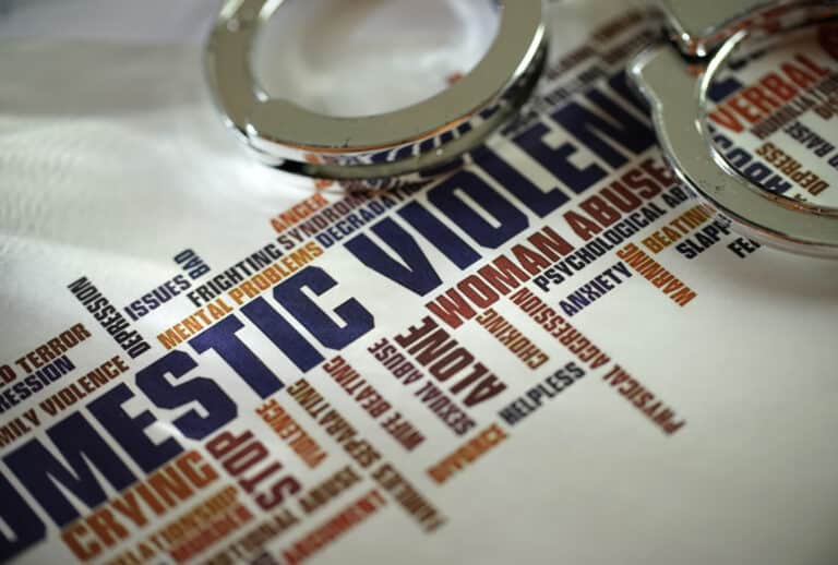 Domestic violence handcuffs on a white background symbolizing the future criminalization of coercive control in Queensland.